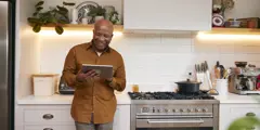 Man On Tablet In Kitchen